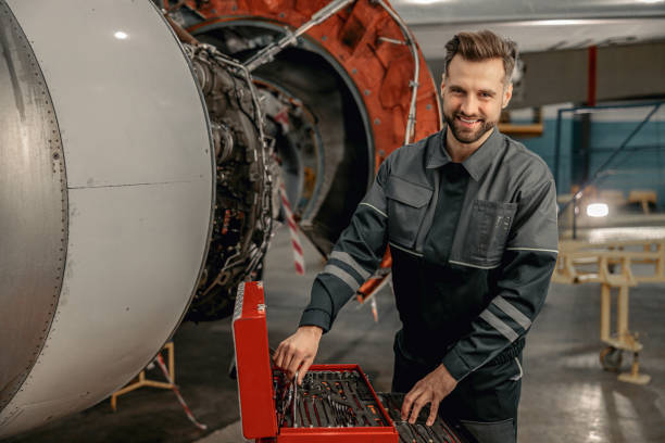 istock Cheerful man aircraft mechanic using tool box in hangar 1384876002