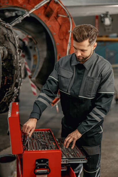 istock Bearded man aircraft mechanic using tool box in hangar 1384876004