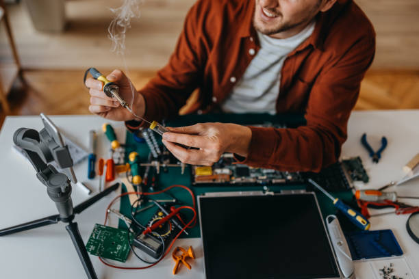 Young man vlogging while repairing laptop at home