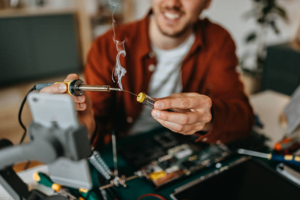 istock Young man vlogging while repairing laptop at home 1384879169