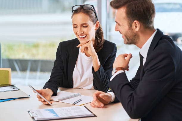 istock Two formal business people discussing company financial data at office 1384883628