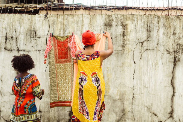 Woman hanging washed clothes with her daughter.