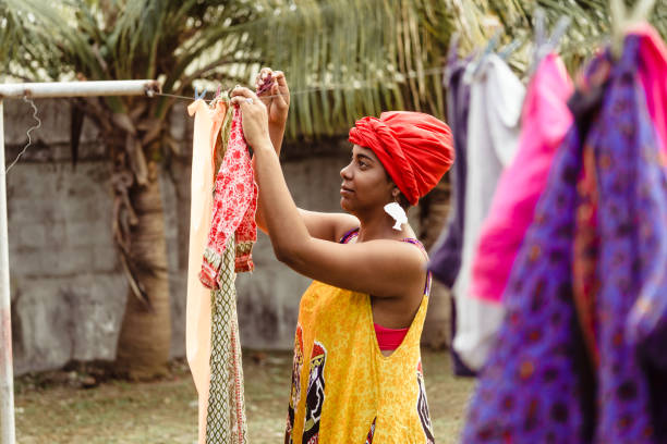 istock Black woman hanging washed clothes. 1384884993