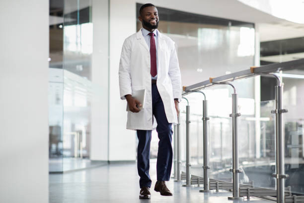 실험실로 걷고 디지털 태블릿을 들고 있는 쾌활한 흑인 과학자 - scientist male young adult doctor 뉴스 사진 이미지