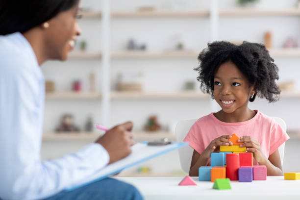 istock Child development specialist having session with cheerful little girl 1384890898