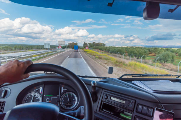 view of the road from the driving position of a truck of a landscape with clouds. - truck driver highway truck working imagens e fotografias de stock