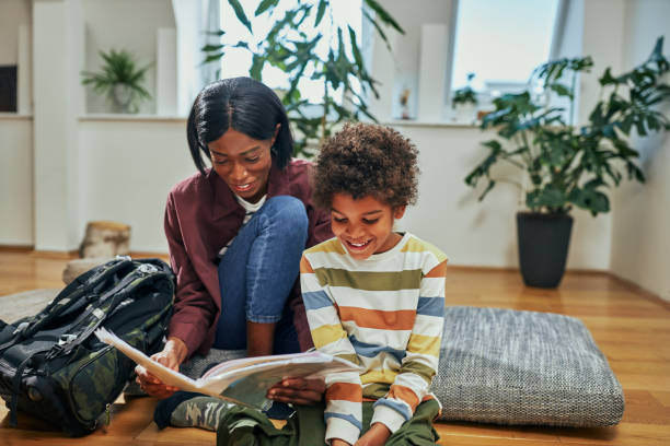 Mother and little son reading book together at home