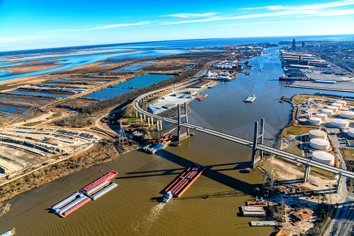 A wide angle aerial view of the Mobile River over the Cochrane-Africatown USA Bridge, with the downtown Mobile in the distance shot from an altitude of about 1500 feet over the river.