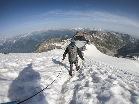One man trekking in the local mountains in Switzerland. People travel nature exploration concept