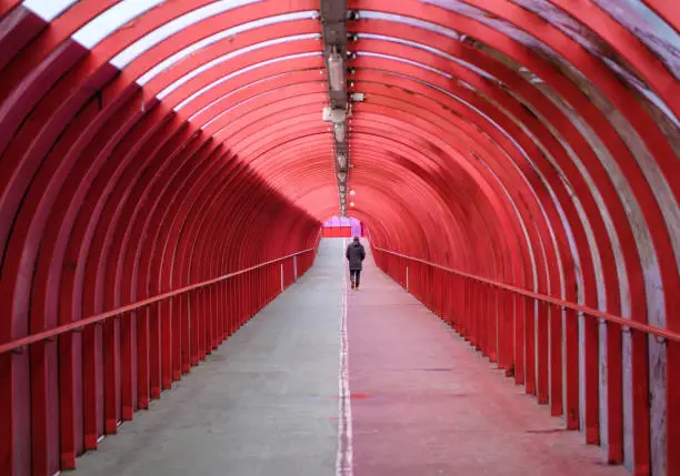Photo of Man Walking Alone In A Covered Walkway