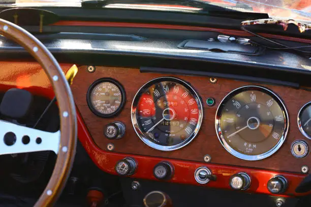 Photo of Instrument panel of a vintage car with a tasteful wood grain interior