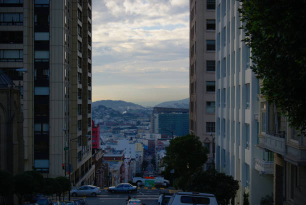The steep streets of downtown San Francisco stretch towards coastline at sunset.