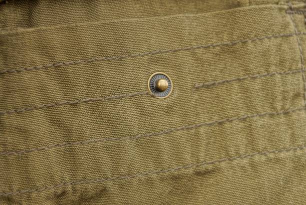 istock one brown metal rivet on the green fabric 1384901573