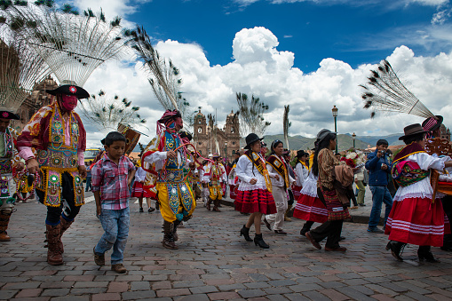 Cuzco, Peru - December 25, 2013: A group of people wearing traditional clothes and masks during the Huaylia on Christmas day at the Plaza de Armas square in the city Cuzco, Peru.