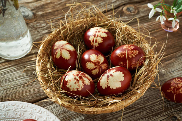 istock Easter eggs dyed with onion peels on a table, with spring flowers 1384907930