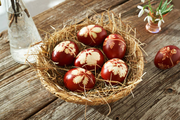 istock Easter eggs dyed with onion peels in a wicker basket on a table with snowdrops 1384907933