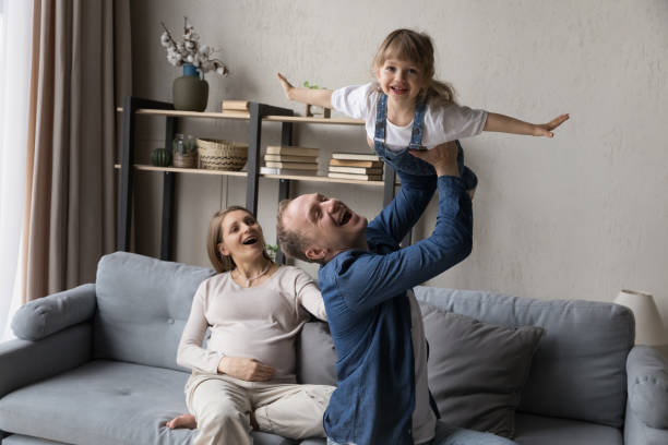istock Excited expecting couple enjoying parenthood, playing with elder daughter kid 1384909055