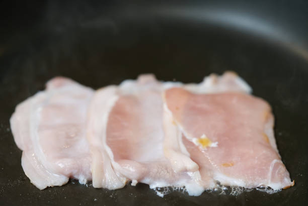 istock bacon in a pan. home food making process 1384919746