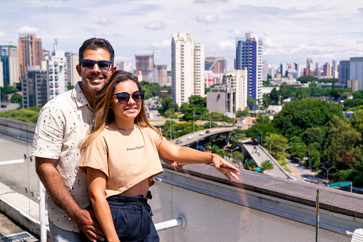 Photo of a couple in Sao Paulo city. The couple is at the top of a building.