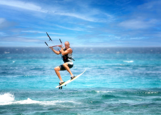 June 22, 2006 - Naxos, Greece.  A man kiteboarding and breaking waves in an area known for its winds and waves, ideal for watersports.