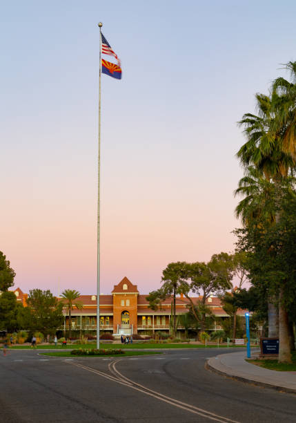 Tucson, AZ - March 9 2022:  American and Arizona flags over Old Main on the campus of the University of Arizona at sunset
