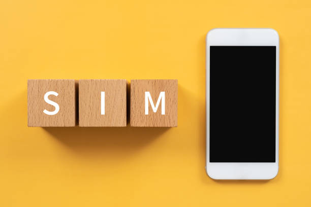 コンセプトとスマートフォンの「sim」テキストを持つ木製のブロック。 - simカード ストックフォトと画像