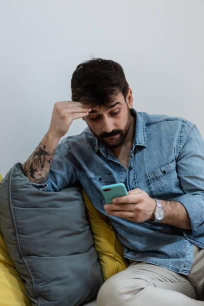 istock Young handsome man bored on his phone 1384930608