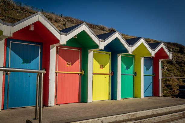 Five brightly coloured beach huts stock photo