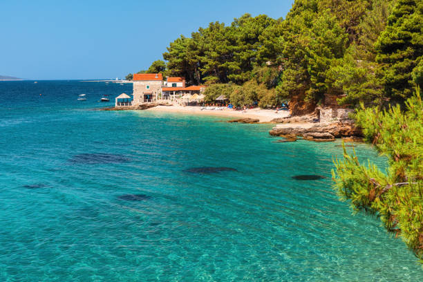 Beautiful view of Adriatic sea with a small restaurant on the pebble beach, Bol, Brac island, Croatia Beautiful view of Adriatic sea with a small restaurant on the pebble beach, Bol, Brac island, Croatia. Summer vacation resort brac island stock pictures, royalty-free photos & images