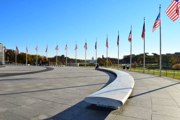 The United States Capitol Building is framed by an arc of American flags at the Washington Monument, Washington, D. C.