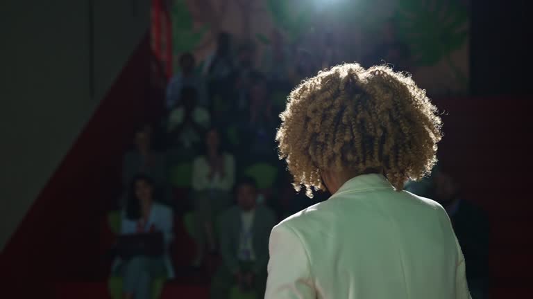 Rear view of the conference speaker giving talk at conference event.