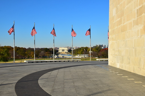 The Lincoln Memorial is framed by American flags as seen from the base of the Washington Monument, Washington, D. C.