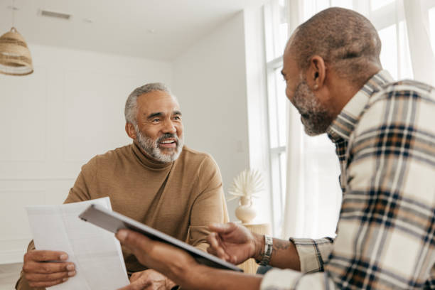 real estate agent and senior men in the living room - family insurance agent real estate financial advisor imagens e fotografias de stock