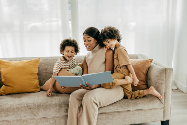 istock Mother reading a book for twins 1384946647