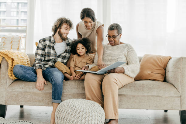 istock Three generation family sitting on the sofa with a book 1384946657