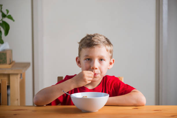 istock Handsome boy eats granola for breakfast. Lifestyle portrait. 1384947002