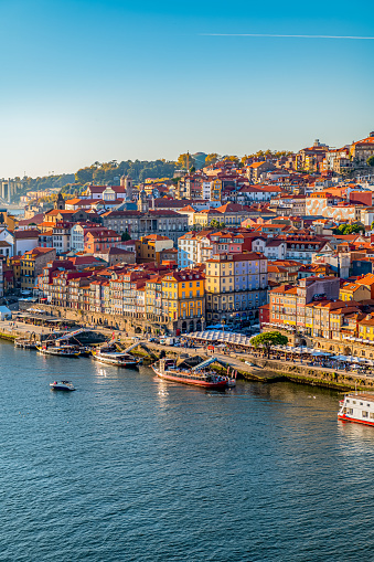 Porto, Portugal - 14 October, 2021: Porto old town embankment on the Douro River and popular touristic root. Beautiful sunny day with blue sky.