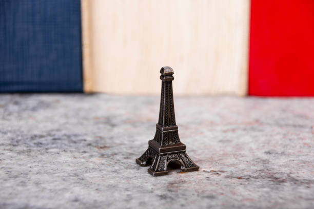 아주 작은 에펠탑 복제본과 뒤에 프랑스 국기의 색상 - eiffel tower flash 뉴스 사진 이미지