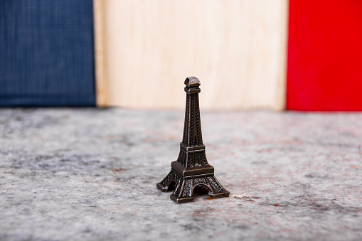 Souvenir, ornament of Eiffel tower over marble table and colors blue, white and red at the back