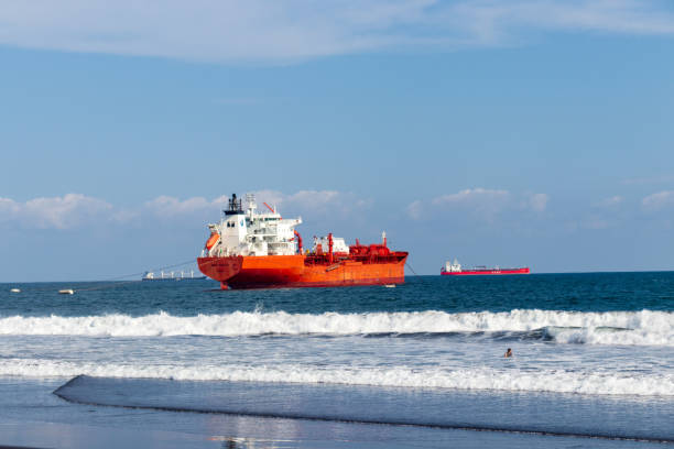 грузовое судно на тихоокеанском побережье на популярном пляже гватемала пуэрто-де-сан-хосе - barge beach large blue стоковые фото и изображения