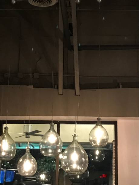 istock Several clear glass pendant lights hanging in front of a window 1384966328