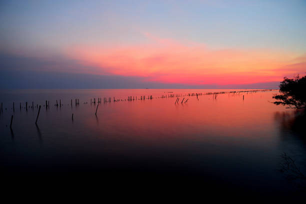 siluetta di cielo vivido sul mare al tramonto - ocean scenic flash foto e immagini stock