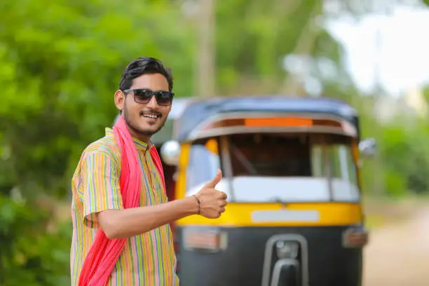 Photo of Indian auto rickshaw three-wheeler tuk-tuk taxi driver man wearing sun glasses