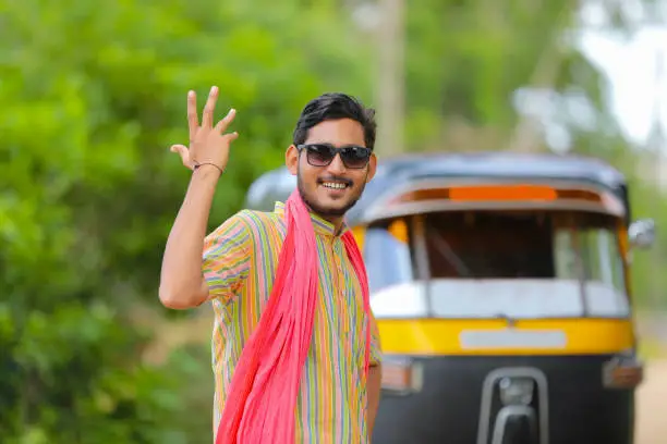 Photo of Indian auto rickshaw three-wheeler tuk-tuk taxi driver man wearing sun glasses