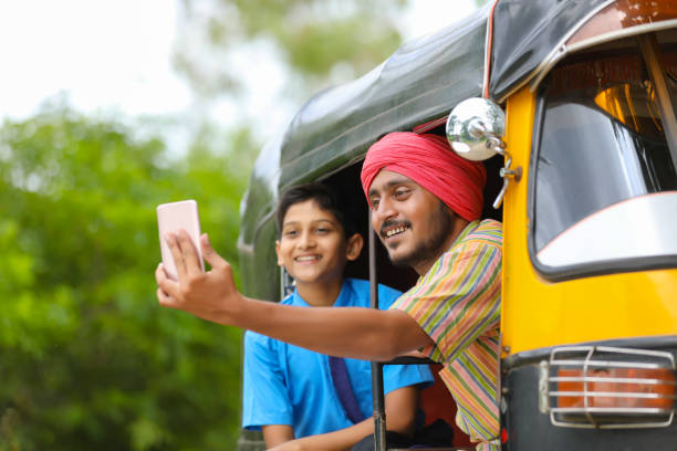 auto rikshaw indiano o autista di tuk tuk che scatta selfie con il suo scolaro - thumps up foto e immagini stock