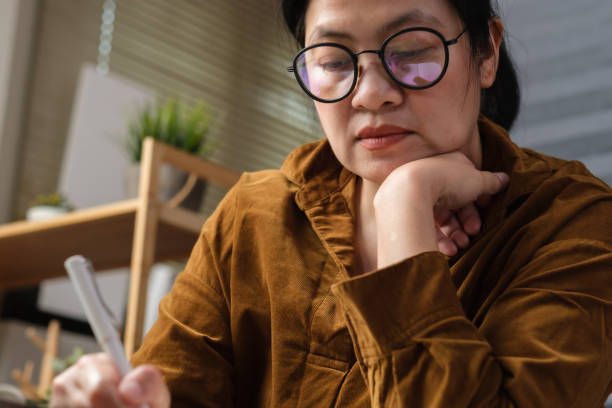 istock asian woman hand writing on notebook at worknig desk at home 1384996552