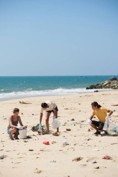 volunteers picking up plastic trash - wasting time imagens e fotografias de stock