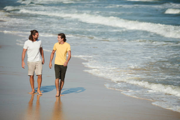 istock Happy Friends Walking on Beach 1385009563
