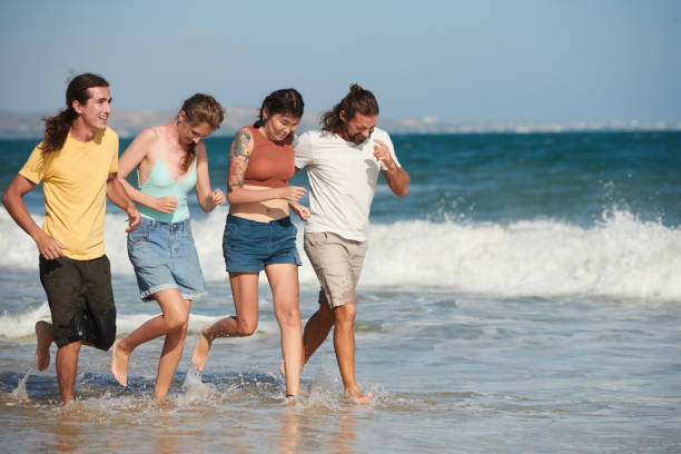 istock Young Men and Women Running on Beach 1385009565