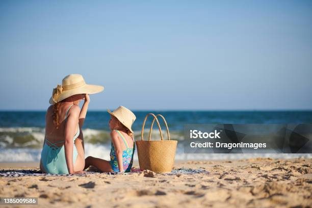 Mother And Daughter Sunbathing On Beach Stock Photo - Download Image Now - Beach, Family, Fun